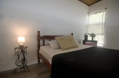 a bedroom with a bed with a lamp and a window at Tiny Bosque del Barro in Barrio Jesús