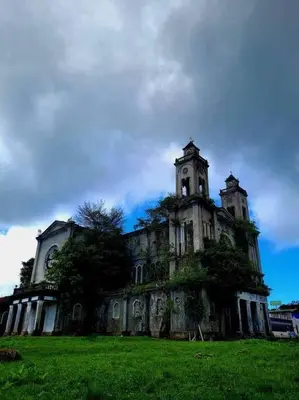 an old building with two towers on a green field at Tita's House in Jarasal