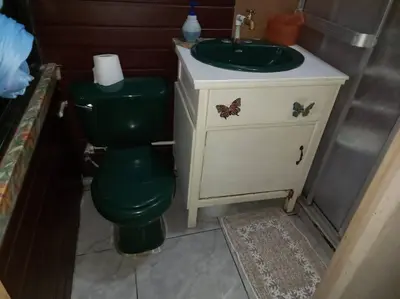 a bathroom with a green toilet and a sink at Tita's House in Jarasal
