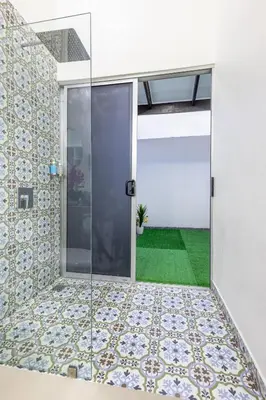 a room with a glass door with a plant at The Zion Suite Tortuguero in Tortuguero