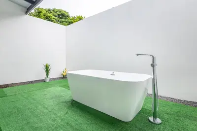 a white bath tub in a room with green grass at The Zion Suite Tortuguero in Tortuguero