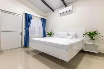 a white bedroom with a large bed and a window at The Zion Suite Tortuguero in Tortuguero