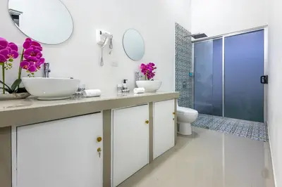 a bathroom with two sinks and a toilet and a shower at The Zion Suite Tortuguero in Tortuguero