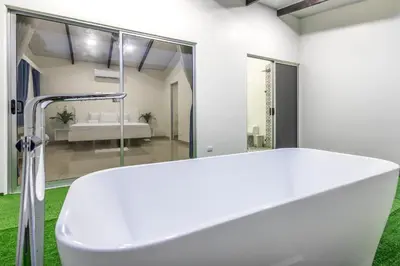 a white bath tub in a bathroom with a shower at The Zion Suite Tortuguero in Tortuguero