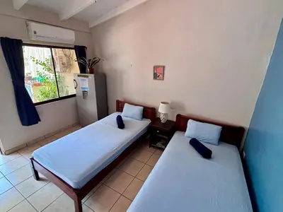 two beds in a small room with a window at Casitas de la Paz in Coco
