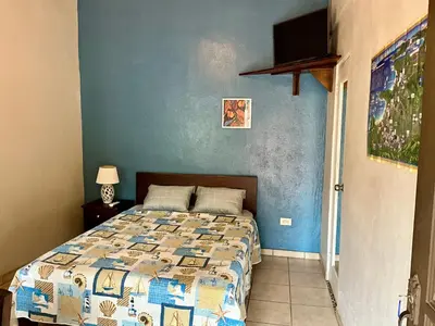 a bedroom with a bed with a blue wall at Casitas de la Paz in Coco