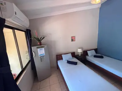 a small room with two beds and a window at Casitas de la Paz in Coco