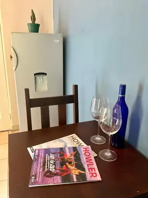 a table with a magazine and two wine glasses at Casitas de la Paz in Coco