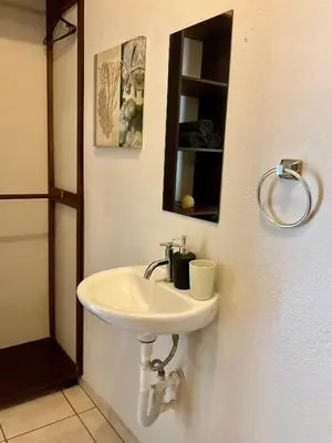 a bathroom with a white sink and a mirror at Casitas de la Paz in Coco