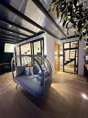 a wicker swing chair in a room with a window at Nest Chalet Monteverde in Monteverde Costa Rica
