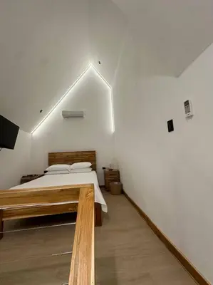 a bedroom with a bed and a white wall at Nest Chalet Monteverde in Monteverde Costa Rica