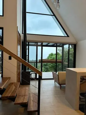 a living room with a large window in a house at Nest Chalet Monteverde in Monteverde Costa Rica