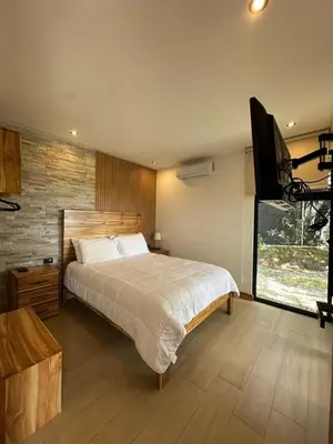 a bedroom with a large bed and a flat screen tv at Nest Chalet Monteverde in Monteverde Costa Rica