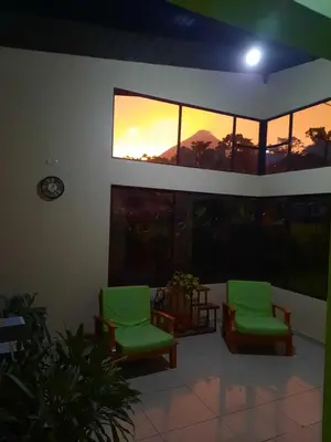 two green chairs in a room with a sunset in the window at Green leaf house in Fortuna