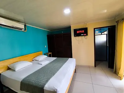 a bed in a room with a clock on the wall at Green leaf house in Fortuna