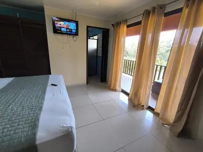 a bedroom with a bed and a tv on the wall at Green leaf house in Fortuna