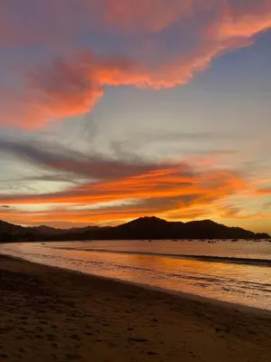 a sunset on a beach with a cloudy sky at Emerald Haven Second Floor Studio Mins from Beach in Coco