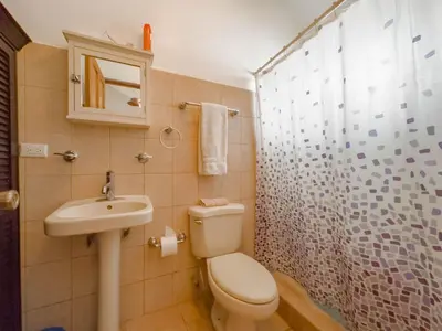 a bathroom with a toilet and a sink and a shower at Emerald Haven Second Floor Studio Mins from Beach in Coco