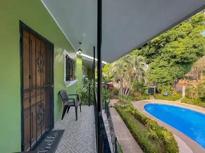 an open door of a house with a patio and a swimming pool at Emerald Haven Second Floor Studio Mins from Beach in Coco