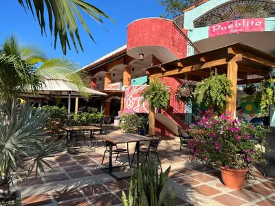 a patio with tables and chairs in front of a restaurant at Emerald Haven Second Floor Studio Mins from Beach in Coco
