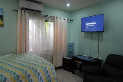 a bedroom with a bed and a flat screen tv at Marine Beach Bliss Ground Floor Studio in Coco