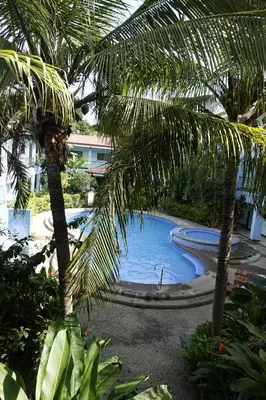 a view of a swimming pool with palm trees at Marine Beach Bliss Ground Floor Studio in Coco