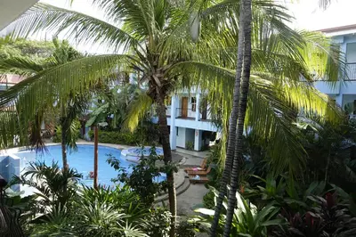 a view of the pool from the balcony of a hotel with palm trees at Marine Beach Bliss Ground Floor Studio in Coco