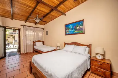 a bedroom with a bed and a table and a chair at Cozy Beachside Studio with Pool and Free WiFi in Playa Grande