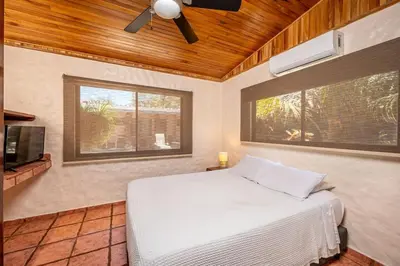 a bedroom with a bed and a ceiling fan at Comfortable Vacation Home Steps from the Beach in Playa Grande