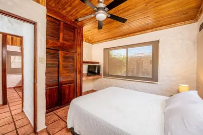a bedroom with a bed and a ceiling fan at Comfortable Vacation Home Steps from the Beach in Playa Grande