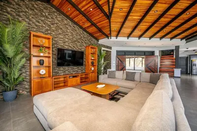 a living room with a couch and a tv at Luxurious Mountaintop Retreat with Ocean Views in Matapalo
