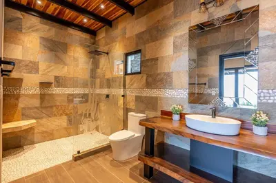 a bathroom with a sink and a toilet and a shower at Luxurious Mountaintop Retreat with Ocean Views in Matapalo