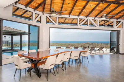 a dining room with a table and chairs with a view at Luxurious Mountaintop Retreat with Ocean Views in Matapalo