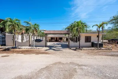 a house with palm trees in front of it at Cozy Seaside Studio Perfect for Families in Playa Grande