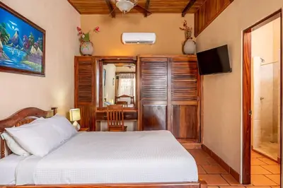 a bedroom with a bed and a television in a room at Cozy Seaside Studio Perfect for Families in Playa Grande