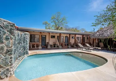 a swimming pool in front of a house at Cozy Seaside Studio Perfect for Families in Playa Grande