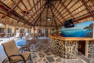 a resort with a bar and tables and chairs at Cozy Seaside Studio Perfect for Families in Playa Grande