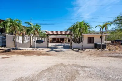 a house with palm trees and a basketball hoop at Charming Studio with Pool & Beach Access in Playa Grande