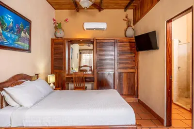 a bedroom with a bed and a flat screen tv at Charming Studio with Pool & Beach Access in Playa Grande