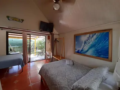 a bedroom with a bed and a large painting on the wall at BeachBungalow Surf&Stay in Patos