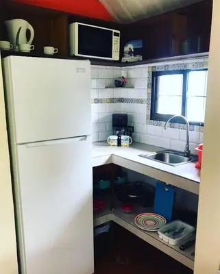 a kitchen with a white refrigerator and a sink at BeachBungalow Surf&Stay in Patos