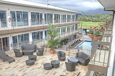 a hotel with a patio with chairs and a pool at Beachfront Hotel Tramonto in Jacó