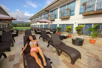 a woman sitting on a chair on a building at Beachfront Hotel Tramonto in Jacó