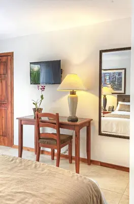 a bedroom with a desk with a lamp and a bed at Beachfront Hotel Tramonto in Jacó