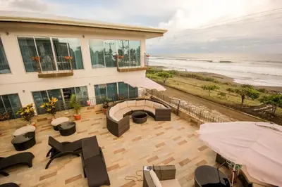 a house with a patio with a view of the beach at Beachfront Hotel Tramonto in Jacó