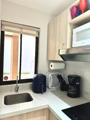 a kitchen counter with a sink and a microwave at Casa Limonada Ground Condo in Coco