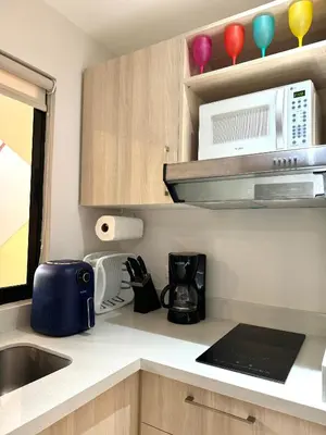 a kitchen with a sink and a microwave at Casa Limonada Ground Condo in Coco