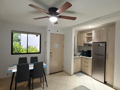 a kitchen with a dining table and a ceiling fan at Casa Limonada Ground Condo in Coco