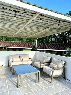 a patio with a table and chairs under a pergola at The Nest 2 bedroom1 bath Condo Rooftop patio in Coco