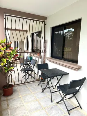 a group of chairs and tables on a balcony at The Nest 2 bedroom1 bath Condo Rooftop patio in Coco